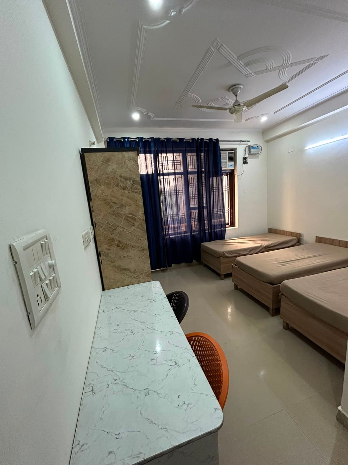 Triple-sharing room at The Fort Residency with multiple comfortable beds